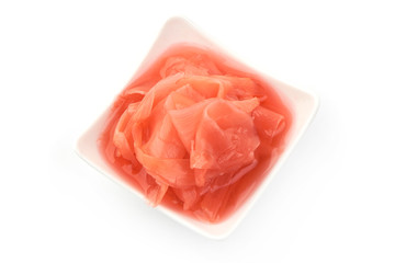 Red pickled ginger in bowl, close-up, isolated on white background. Top view