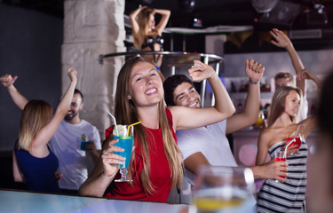 Woman dancing in the night club with drinks