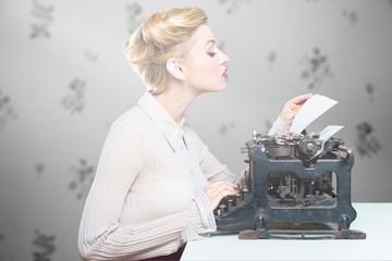 Young blonde female writer using typing machine, black and white portrait