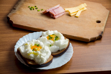 Orsini eggs on bread on wooden with cheese and ham