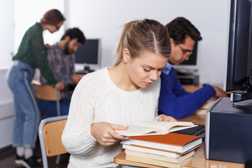 Fototapeta na wymiar female student reading textbook while studying