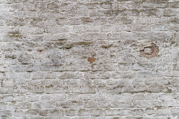 Old gray stone wall with broken plaster as a background