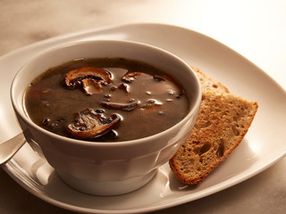 A bowl of mushroom soup with bread