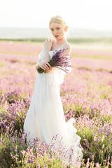 Fototapeta na wymiar Wonderful portrait of girl in light dress in lavender field on sunset