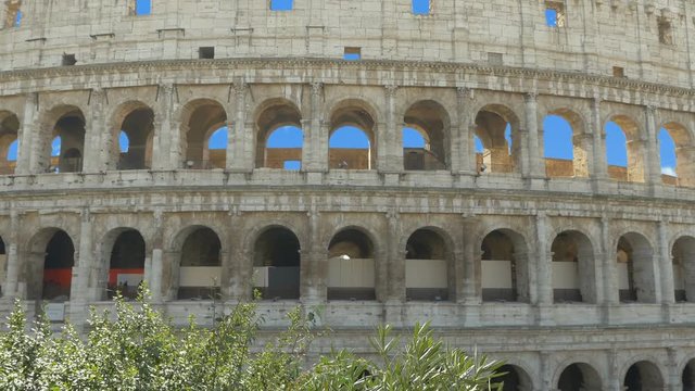 Little girl is holding a phone in her hands and taking pictures of Colosseum, more options in my portfolio