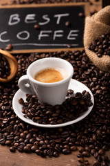 Cup of coffee surrounded by coffee beans