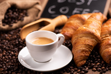 Cup of coffee surrounded by coffee beans