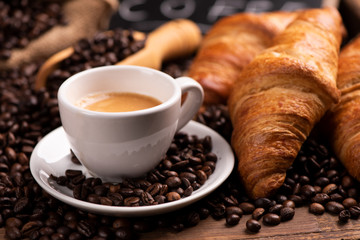 Cup of coffee surrounded by coffee beans