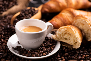 Cup of coffee surrounded by coffee beans