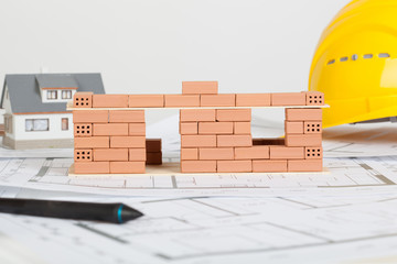 Model house construction with brick on blueprint