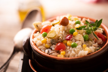 Rice salad in a bowl on wooded table