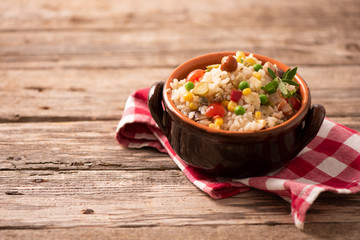 Rice salad in a bowl on wooded table