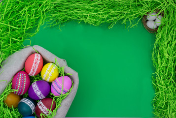 Basket with Easter eggs on a green background