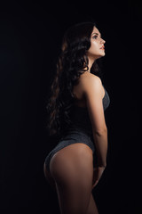 Fototapeta na wymiar Sexy beautiful brunette woman posing in silver swimsuit in studio. Girl with perfect slim body.