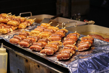 Sausages fried on a stick from different sorts of meat. Asian fa