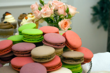 Fototapeta na wymiar colorful Macarons cakes on a platter with rose as background