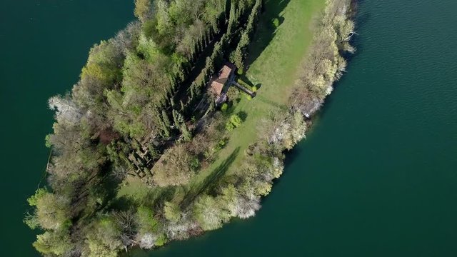 piccola isola abitata con casa e canoe  che navigano, vista aerea