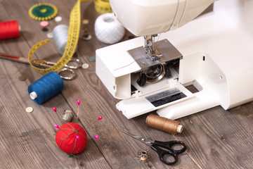 Seamstress or tailor background with sewing tools, colorful threads, sewing machine and accesories.
