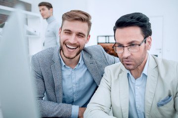 Fototapeta premium smiling colleagues looking at the computer monitor