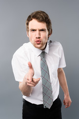 angry businessman with funny face expression pointing with finger at camera