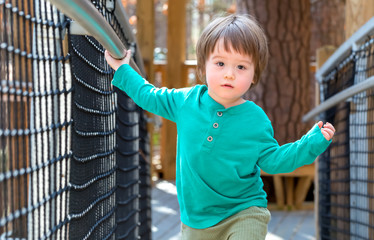 Toddler boy playing outside at a playground