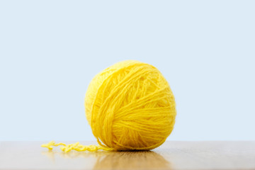 Yellow ball of thread on a light background. Craft or knitting concept. The idea of solving the case.