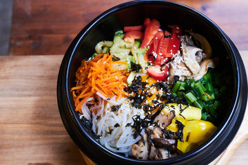 Asian dish in black bowl with vegetables