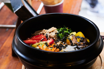 Asian dish in black bowl with vegetables