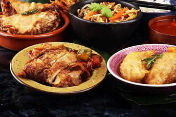 Assorted Chinese food set. Chinese noodles, fried rice, peking duck, dim sum, spring rolls. Famous Chinese cuisine dishes on table. Chinese restaurant