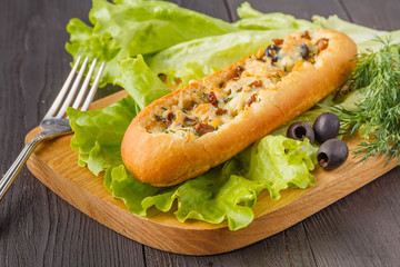 Baguette stuffed with bolognese ragout of minced beef, tomatoes and cheese. A delicious Italian lunch, tasty snacks, homemade sandwich