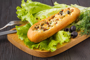 Baguette stuffed with bolognese ragout of minced beef, tomatoes and cheese. A delicious Italian lunch, tasty snacks, homemade sandwich
