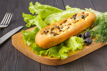 Baguette stuffed with bolognese ragout of minced beef, tomatoes and cheese. A delicious Italian lunch, tasty snacks, homemade sandwich