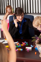 Stressed Businesswoman with Children in Office - Working Mom