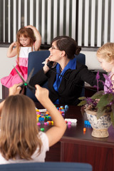 Fototapeta premium Stressed Businesswoman with Children in Office - Working Mom