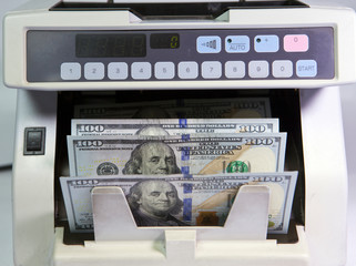 electronic money counter machine is counting is counting the American hundred-dollar (US dollars) banknotes