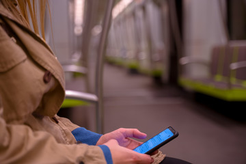 Young woman texting while sitting in the wagon. Subway