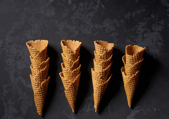 stacked tower of empty ice-cream cones on dark background, top view.,