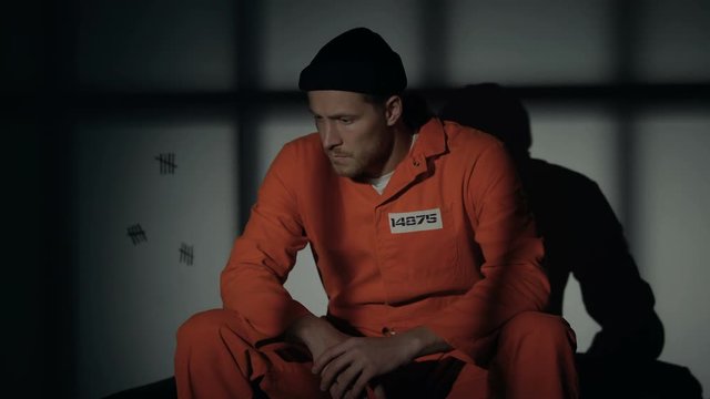 Male prisoner sitting in cell when light starting to blink, escape and riot risk