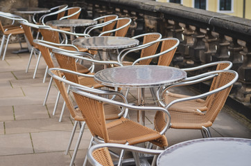 Row of empty tables with chairs in an outdoor cafe. Close up.