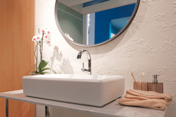 Luxury faucet mixer on a white sink in a beautiful beige gray bathroom