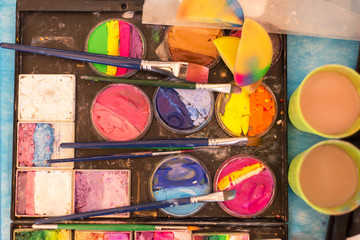 Many color paint and brushes on palette. Artist's workplace. Drawing, creativity, art