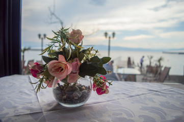 Beautiful arranged table flowers sitting on a dining table with a lake few