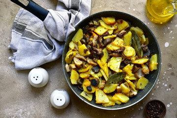 Fried potato with wild mushrooms in a skillet.Top view with copy space.