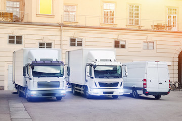Different small and medium courier service  trucks and van at building courtyard. City delivery cargo shipping company vehilcles parked at street © Kyryl Gorlov