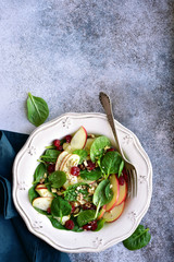 Vegan spinach salad with apple, dried cranberry and walnut.Top view with copy space.