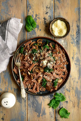 Obraz na płótnie Canvas Whole wheat fusilli pasta with mushroom and spinach.Top view with copy space.