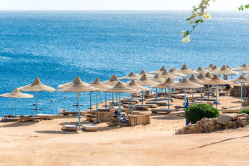 Travel and recreation, sun umbrellas, sun beds on the background of the blue sea