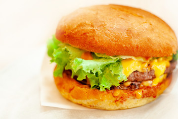 Cheeseburger Or Hamburger With Beef Cutlet, Tomatoes And Cheese Slices, Seasoned With Sauce And Green Salad On White Background.