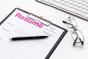 Review resumes of applicants set with keyboard and glasses white work desk background