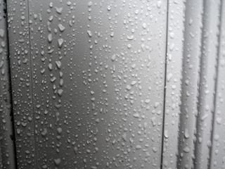 rain drops on the side of a white metal door